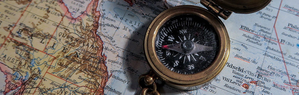 a compass resting on top of a world map